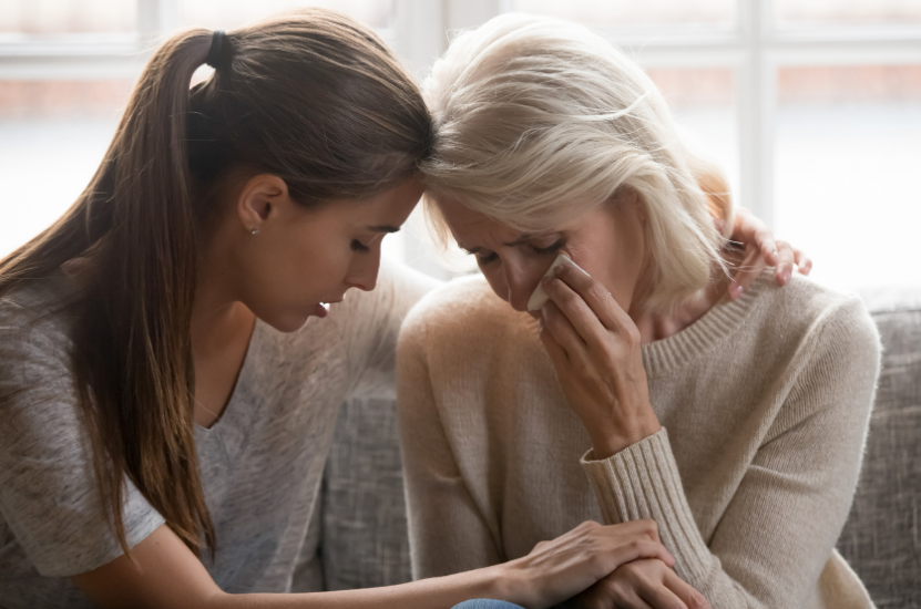 Young woman consoling older woman for wrongful death.